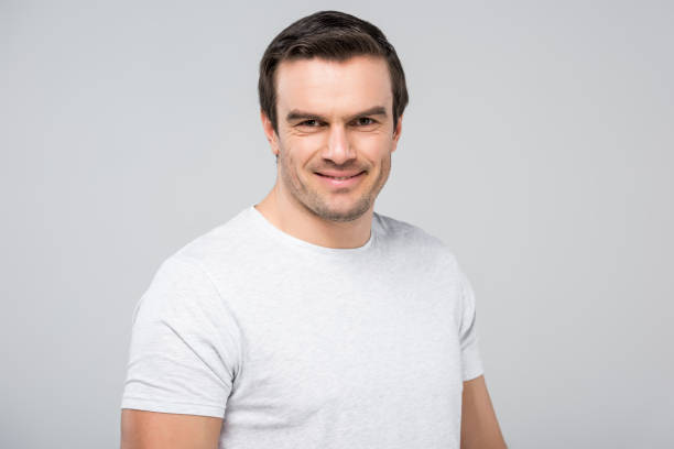 istock portrait of handsome man smiling at camera, isolated on grey 1010099712
