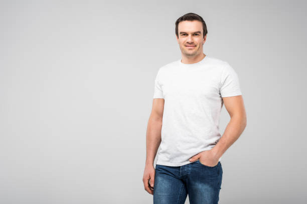 istock smiling handsome man with hand in pocket, isolated on grey 1010099728