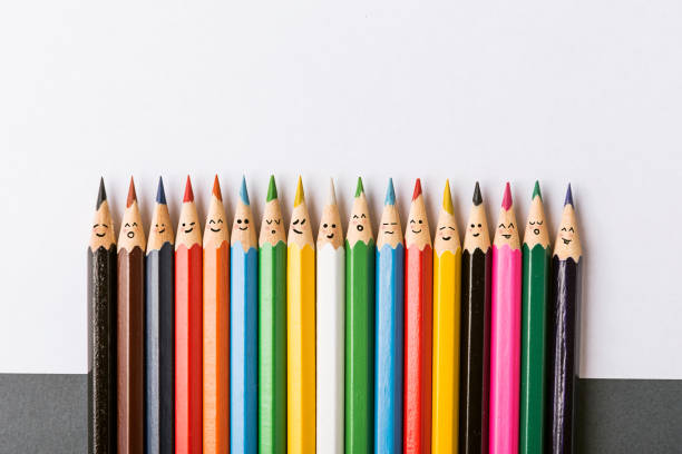 colour pencils Color pencils with faces painted on them. the concept of a multinational family and equality in the world. social inclusion photos stock pictures, royalty-free photos & images