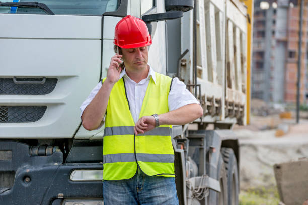 Construction site engineer looking at the time on his watch. stock photo