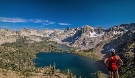 Girl standing on top of Snowyside Pass, looking down upon Twin Lakes of the Sawtooth Mountains.