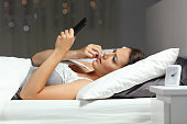 Nervous woman reading phone message in the night