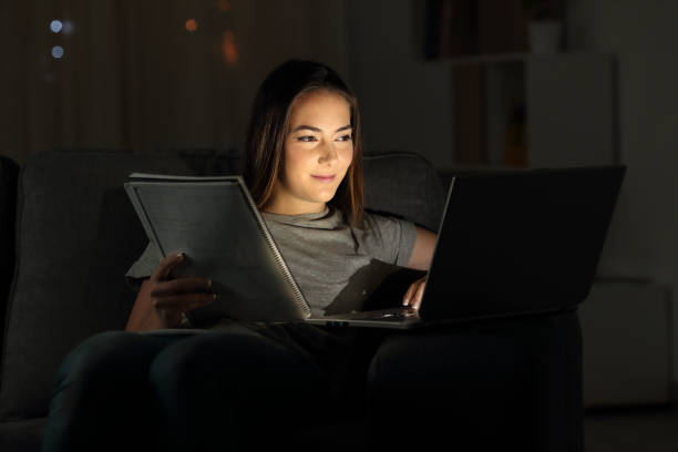 estudiante feliz en línea en la noche - effort dark concepts women fotografías e imágenes de stock