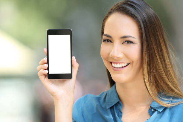 istock Happy lady showing a blank phone screen mock up 1010132996