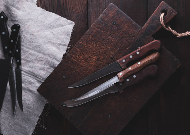 istock very old cutting brown wooden board and kitchen knives 1010143056