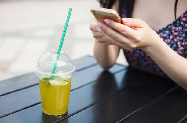 istock Young girl with rfreshing drink and smartphone 1010146546