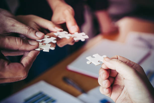 istock Team placing four puzzles jigsaw together for team concept 1010148844