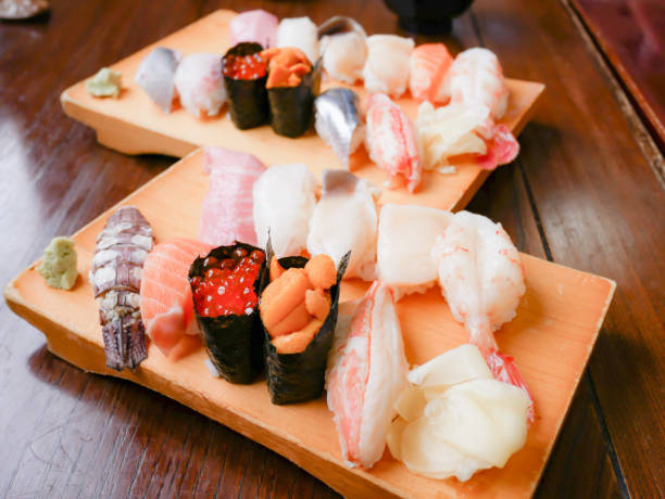 Sushi set from Otaru, Hokkaido, Japan. Variety of sushi such as Shrimp, Carp, Urshin, Tuna sushis on wooden plate. stock photo