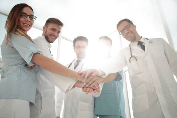 врачи и медсестры координируют руки - huddle business expertise human hand стоковые фото и изображения