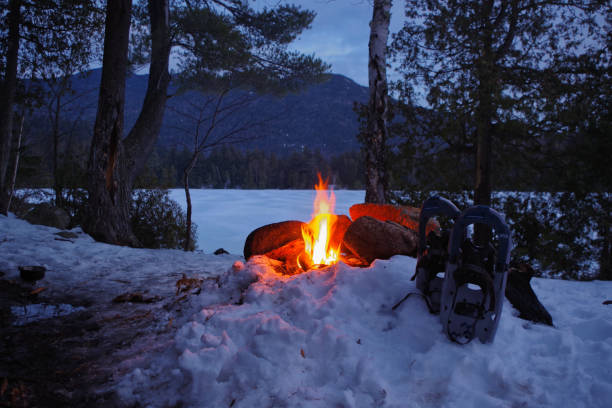 Winter Campfire on Copperas Pond with Snow Shoes in the Adirondack Mountains of Upstate New York. stock photo