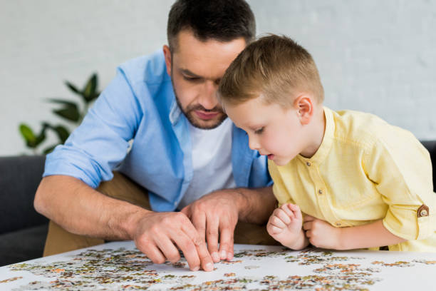 istock focused father and son playing with jigsaw puzzle together at home 1010159768