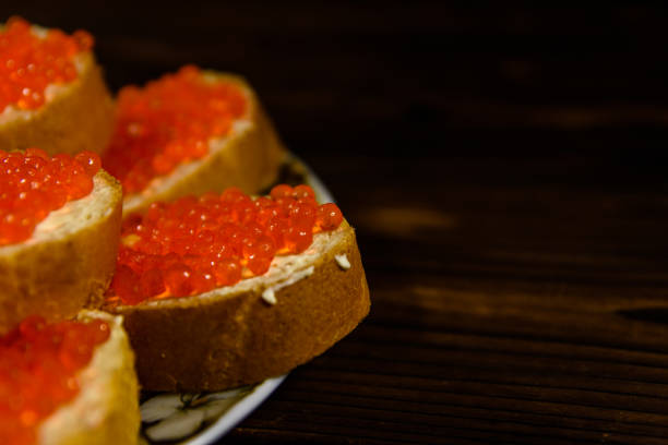 istock Sandwiches with red caviar on wooden table 1010160418