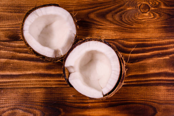 istock Ripe halved coconut on a wooden table. Top view 1010160470