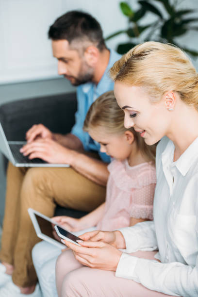 istock family with one child using gadgets while sitting together at home 1010161226