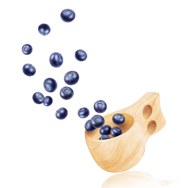 istock Blueberries fly out of a wooden cup on white background 1010169934
