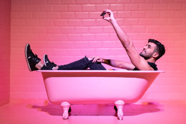 Man Taking a Selfie in the pink bathtube