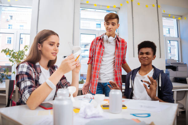 istock Two boys disliking idea of their colleague about launching startup 1010198076