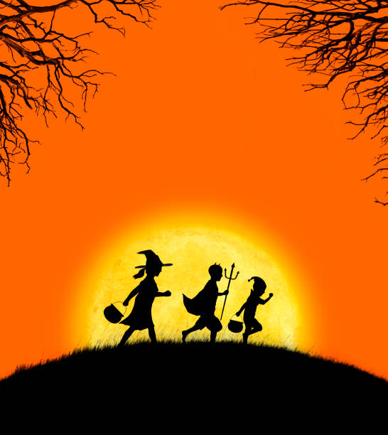 istock Three Children Dressed Up For Halloween Silhouetted Against Moon And Orange Sky 1010201746