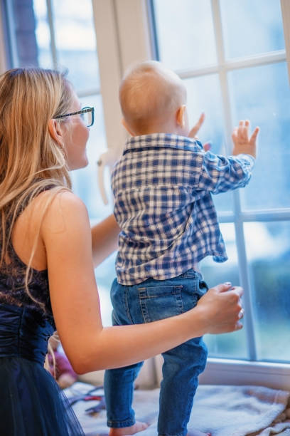 istock Mother with baby boy looking out the window. 1010202674