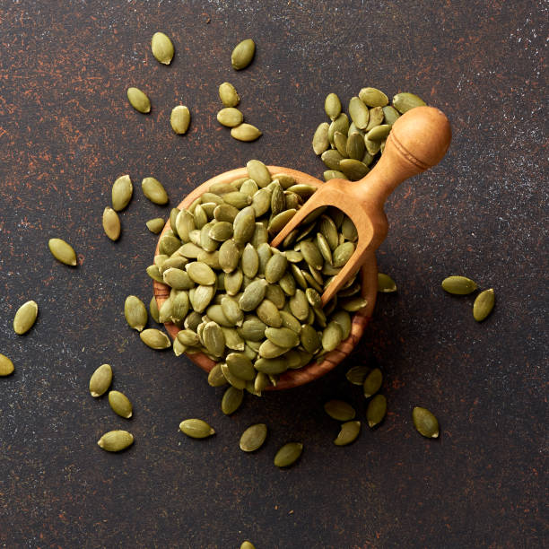 istock Pumpkin seeds on brown background. 1010207556