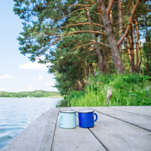 istock two metal cups with tea. river on background. summer time concept 1010210900