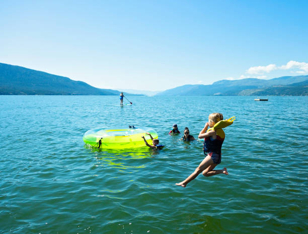 la bambina salta nel lago okanagan - life jacket little boys lake jumping foto e immagini stock
