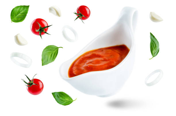 Marinara sauce with flying ingredients to prepare it isolated