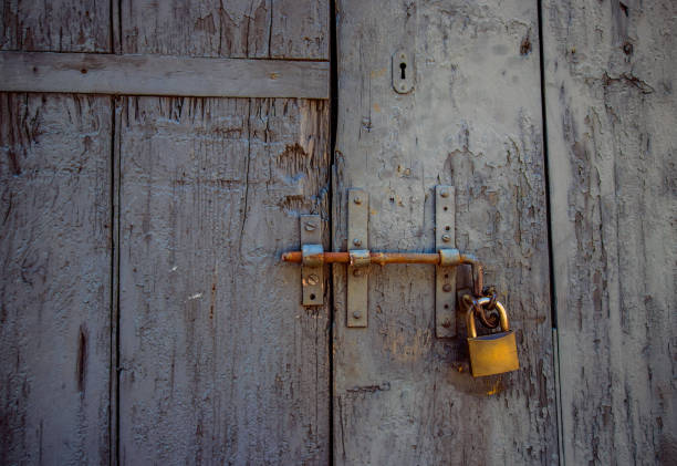 istock Old textured wooden door with padlock, close-up 1010215978