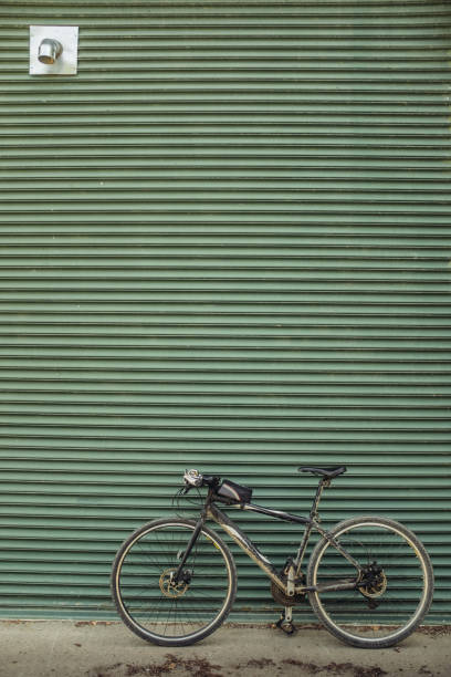 Wide angle image of city bicycle parked against rustic aluminum shutter gate. Urban setting of large North American city.
