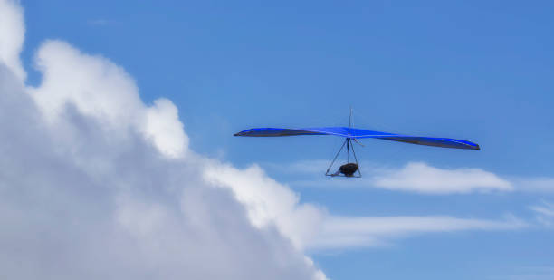 istock Hang Glider flying in the sky on a sunny bright blue day 1010231618