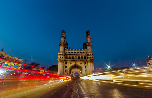 Red and Yellow light trails cut across the charminar of Hyderabad as the sun dips down.