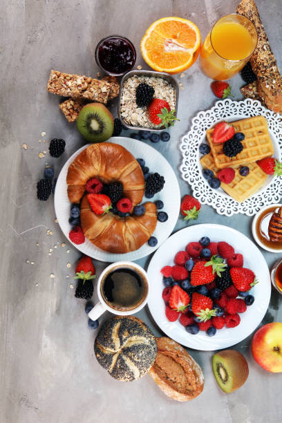 istock breakfast on table with waffles, croissants, coffe and juice. 1010240976