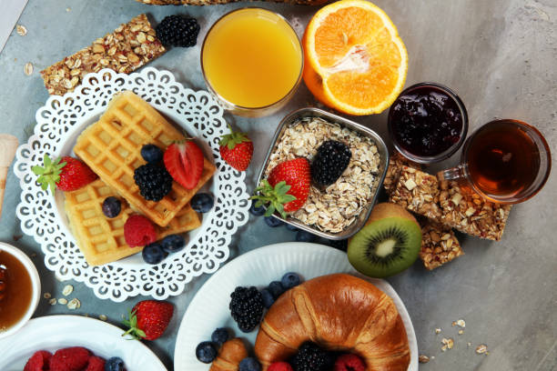 istock breakfast on table with waffles, croissants, coffe and juice. 1010241062