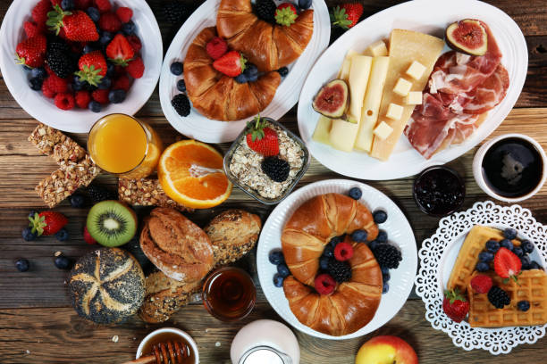 istock breakfast on table with waffles, croissants, coffe and juice. 1010241380