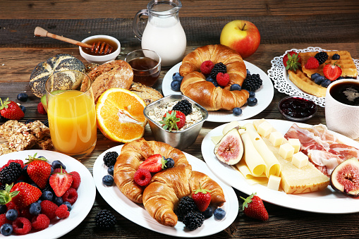 breakfast on table with waffles, croissants, coffe and juice