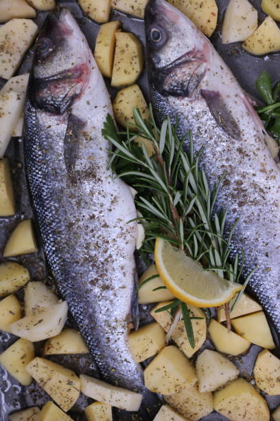 sea bass with potatoes - sea bass prepared fish food grilled imagens e fotografias de stock