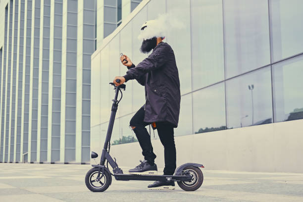 istock A man vaping and riding by electric scooter. 1010249712
