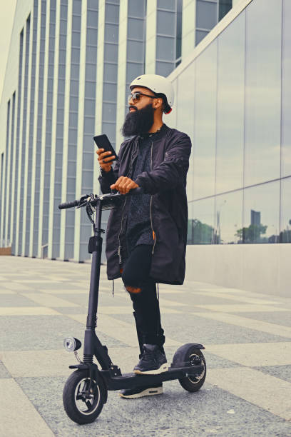 istock A man riding by electric scooter and using a smart phone. 1010252400