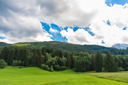 Idyllic landscape in the Alps with green meadows and clouds