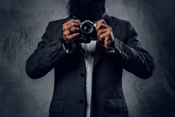 istock Professional photographer in a suit shooting with a compact DSLR camera. 1010258872