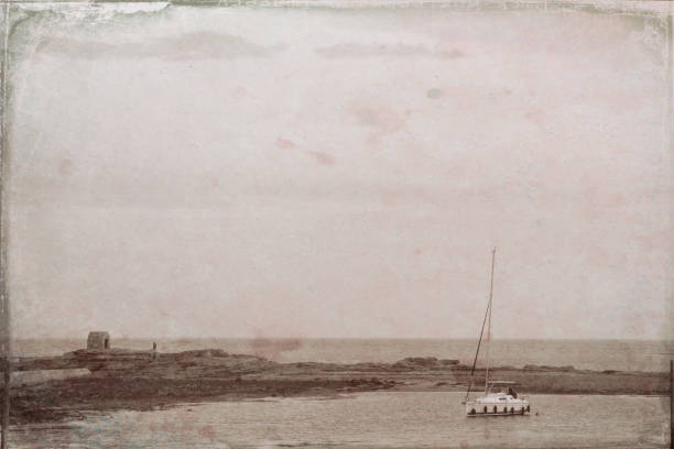 The long pier at Seahouses harbor the embarkation point for Farne Islands cruises in Northumberland. Post processed to give an antique parchment look.