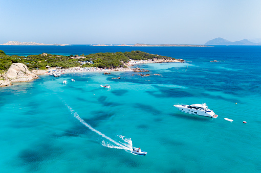 View from above, aerial view of an emerald and transparent mediterranean sea with a white beach and some boats and yachts. Sardinia, Sardinia, Italy.