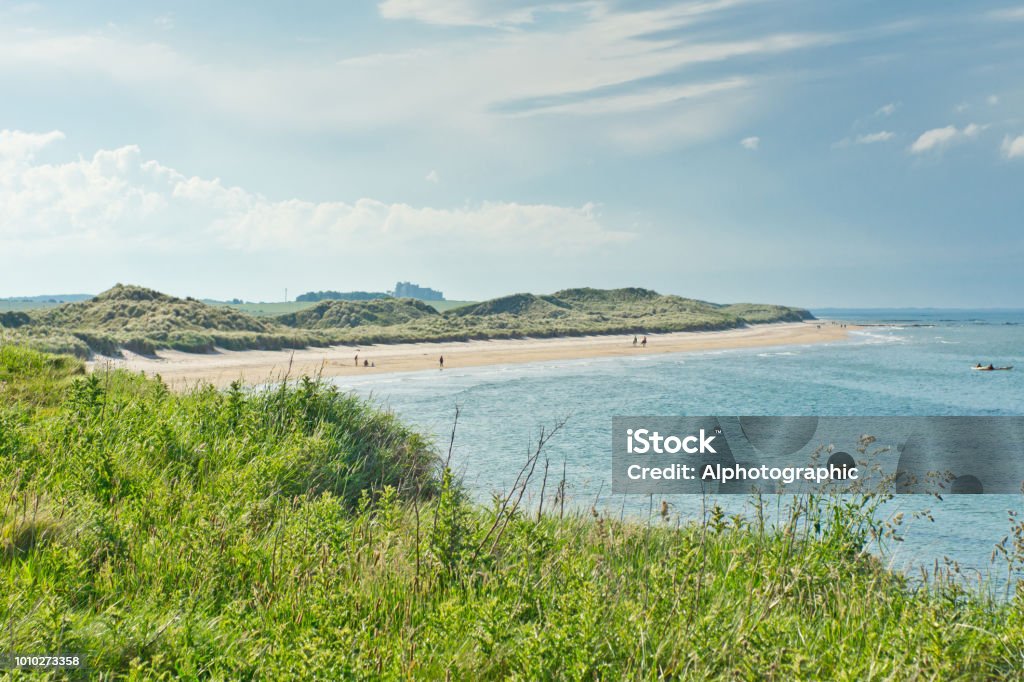 North Sunderland Beach North Sunderland Beach just north of Seahouses harbor, the embarkation point for Farne Islands cruises in Northumberland. Bamburgh castle is just visible in the background. Bamburgh Castle Stock Photo