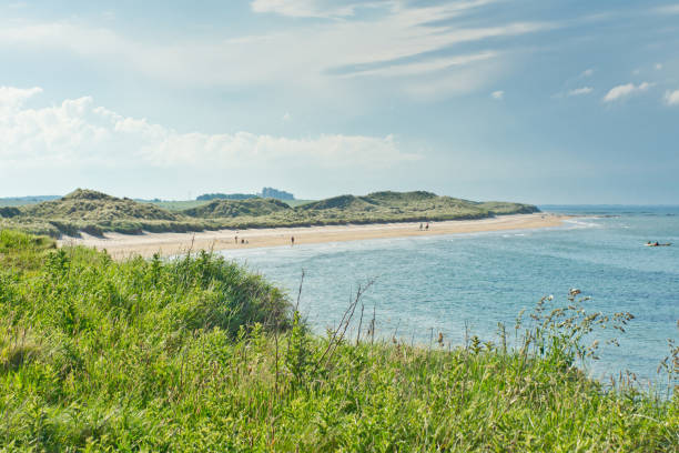 North Sunderland Beach North Sunderland Beach just north of Seahouses harbor, the embarkation point for Farne Islands cruises in Northumberland. Bamburgh castle is just visible in the background. Bamburgh stock pictures, royalty-free photos & images