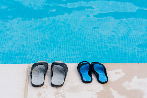 Empty swimming pool and shoes of man and woman close up