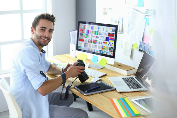 istock Portrait of young designer sitting at graphic studio in front of laptop and computer while working online. 1010298148