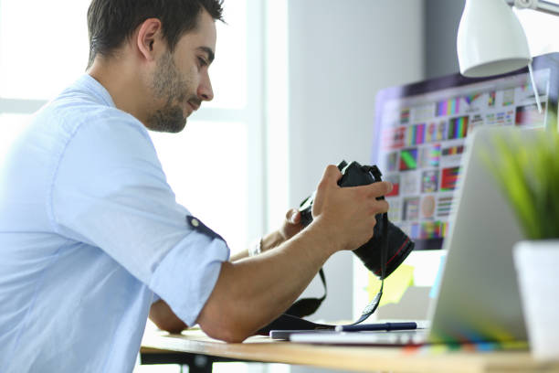 istock Portrait of young designer sitting at graphic studio in front of laptop and computer while working online. 1010300292