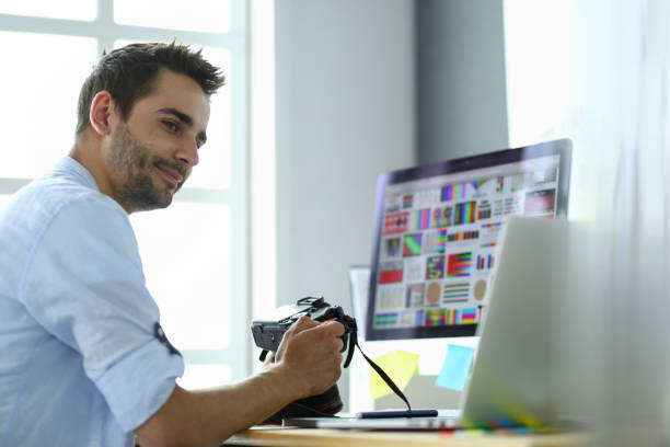 istock Portrait of young designer sitting at graphic studio in front of laptop and computer while working online. 1010300308