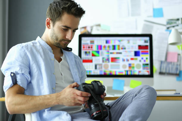 istock Portrait of young designer sitting at graphic studio in front of laptop and computer while working online. 1010300328