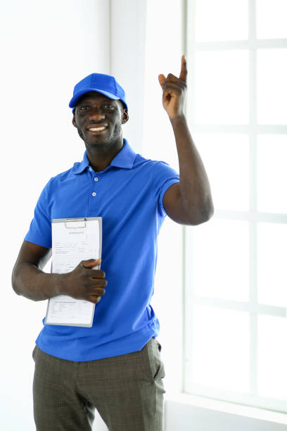 portrait of an handsome happy deliverer with folder - mail van imagens e fotografias de stock